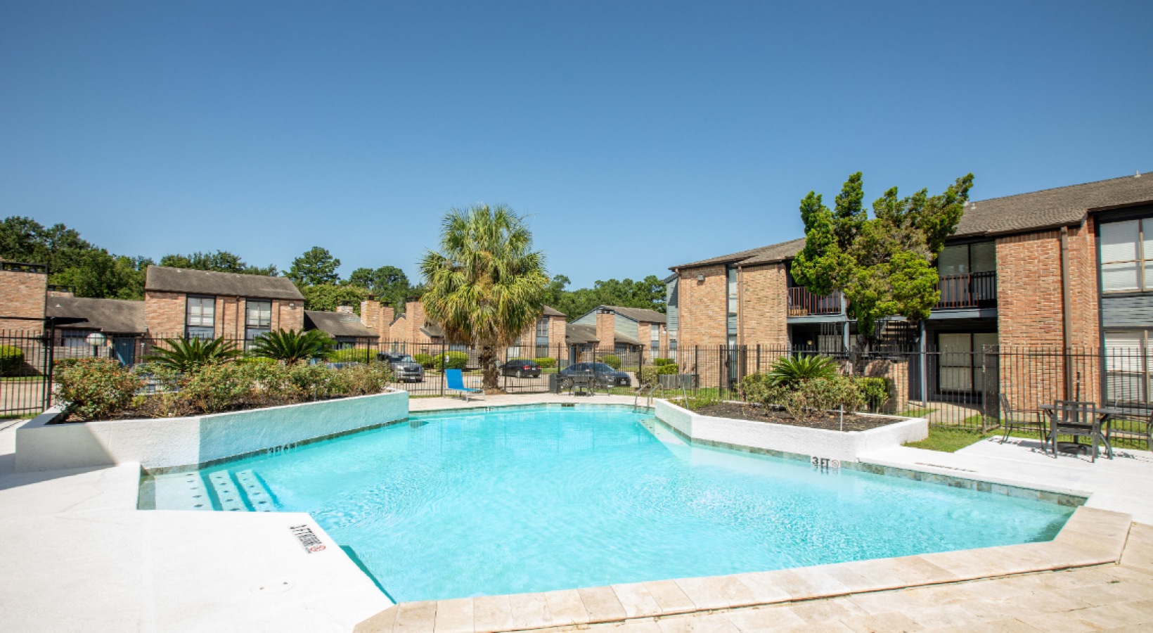 pool deck with blue sky and apartment buildings