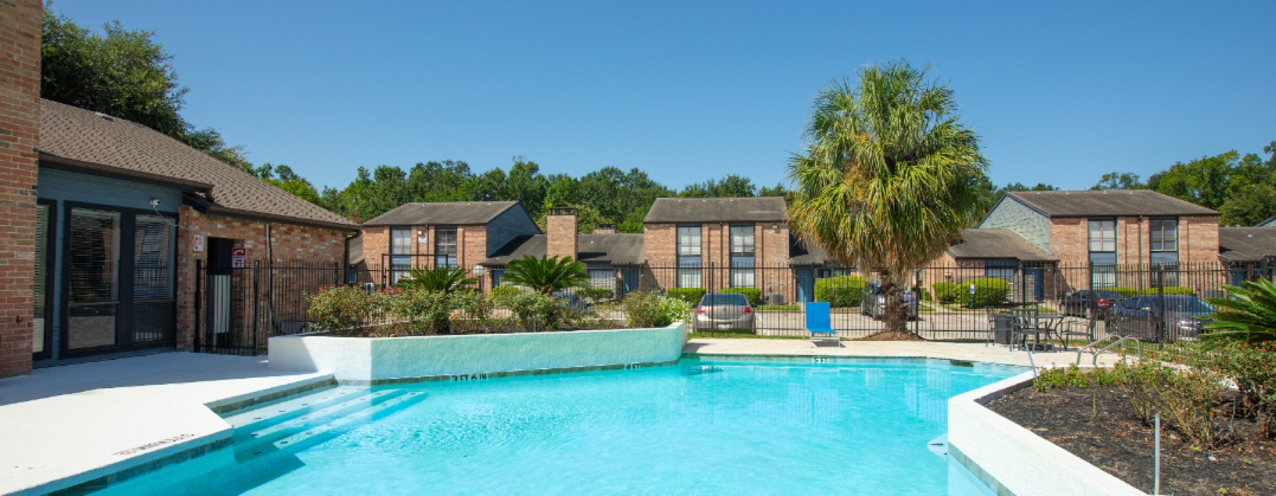 pool deck with blue sky and apartment buildings