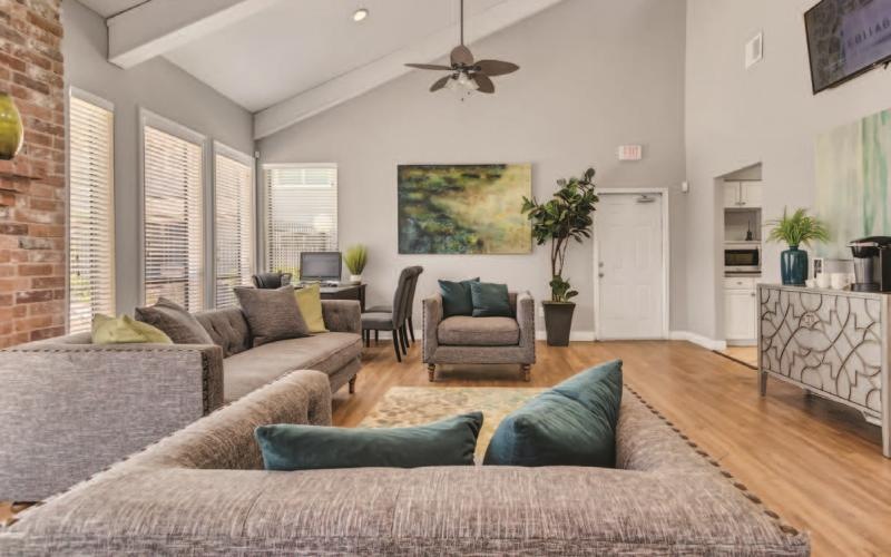 a large clubroom with a couch and a fan